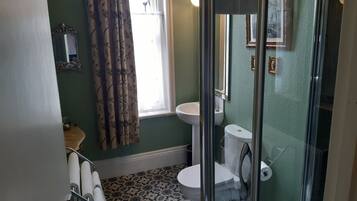 A bathroom with a toilet, sink, and shower area.