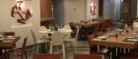 Un comedor moderno con mesas y sillas de madera, una zona de servicio central y obras de arte en las paredes.