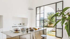 Een moderne keuken met een groot eiland, barkrukken en uitzicht op de omgeving.
