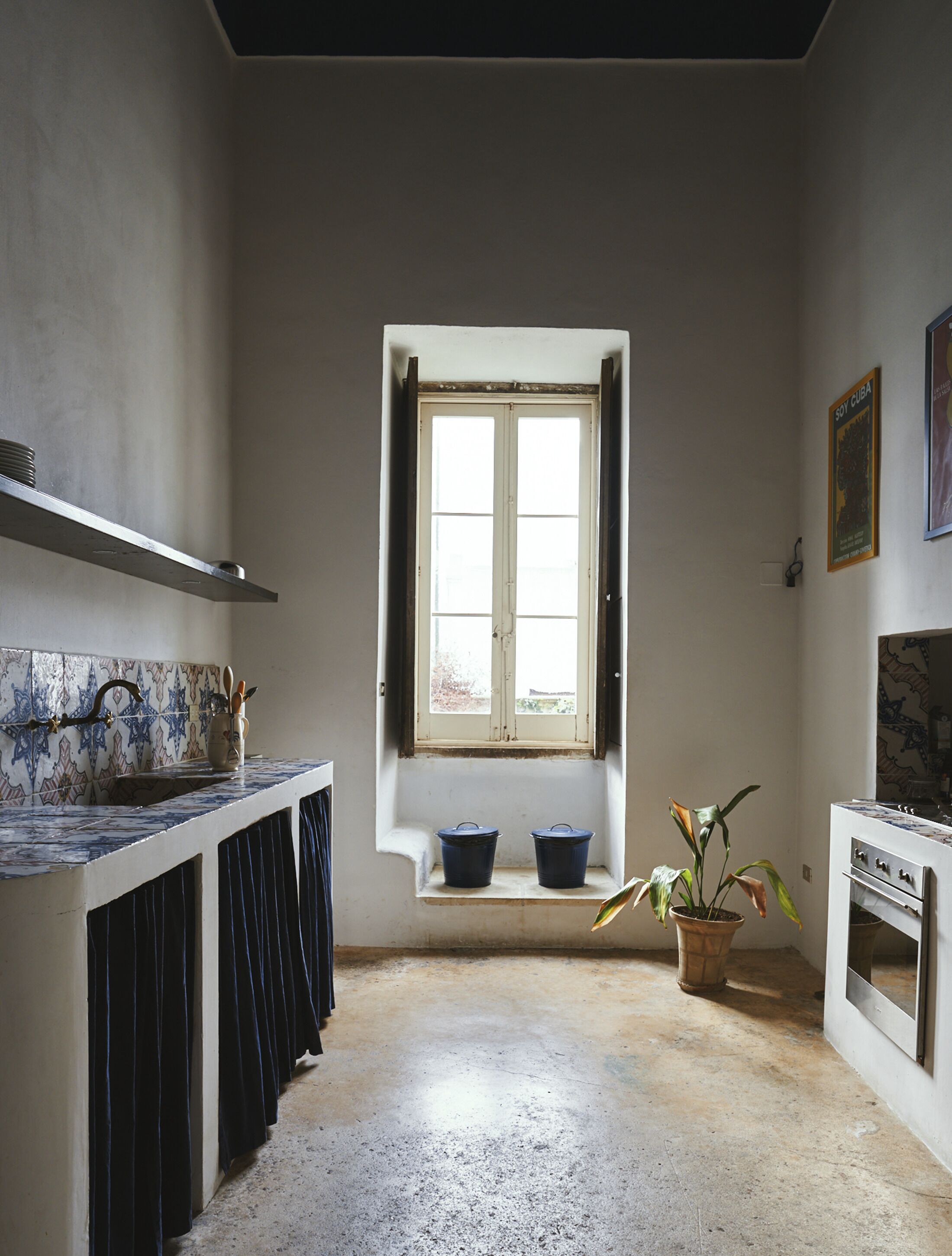 A kitchen with a window, a stove, and a potted plant.
