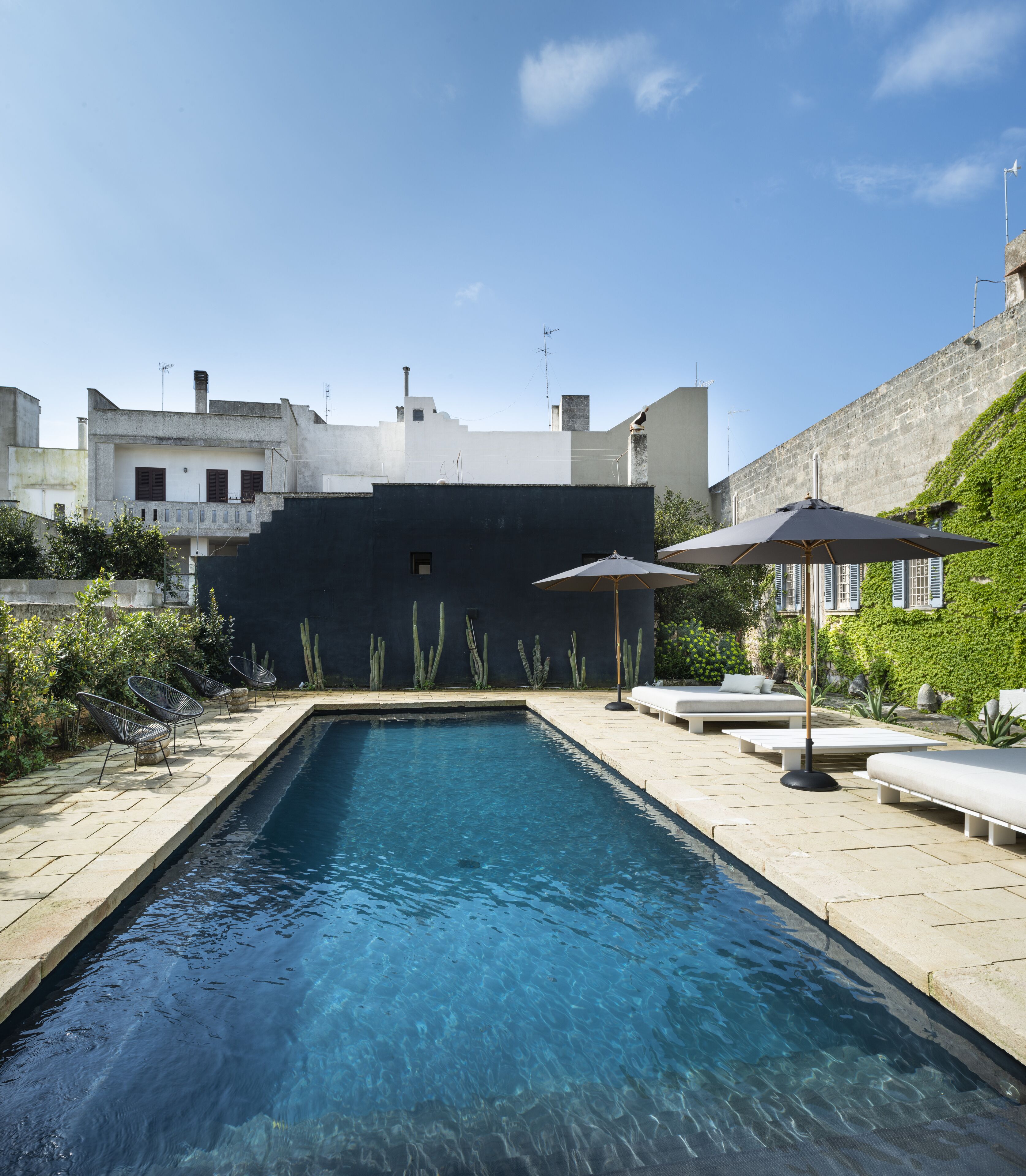 Una piscina al aire libre de temporada, sombrillas