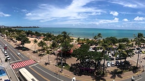 A coastal road with a beach and palm trees. - Happy Hotel Pajuçara (Maceió)