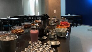 A buffet setup with various food items and beverages. - Happy Hotel Pajuçara (Maceió)