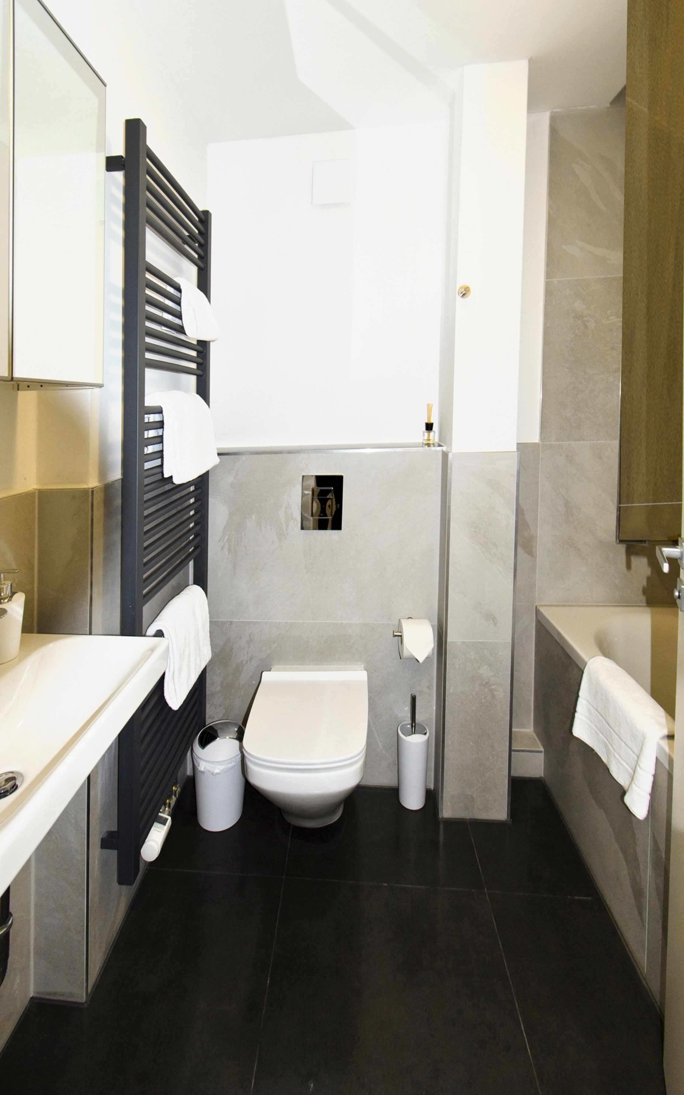 Une salle de bain moderne équipée de toilettes, d’un lavabo et d’une baignoire.