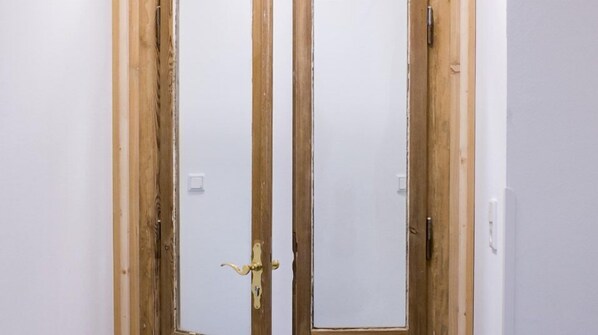 A room with two wooden doors, one with a brass handle.