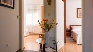 Une chambre d’hôtel avec une table en verre, un vase de fleurs, un lit et une table de chevet.