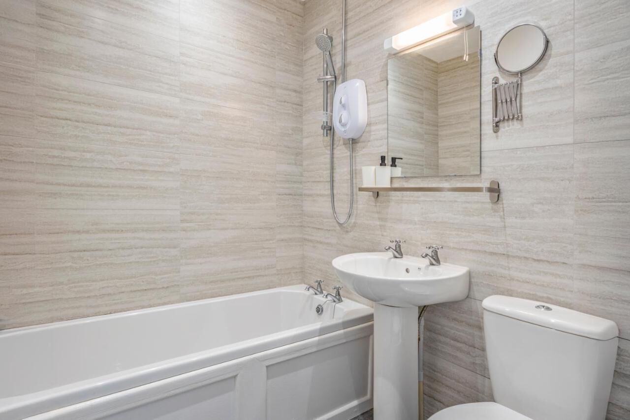 A modern bathroom with a bathtub, a sink, and a toilet.