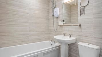 Un baño moderno con bañera, lavamanos e inodoro.