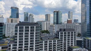 A cityscape with modern high-rise buildings, including a prominent Deloitte building. - Chopin Apartments Eco (Warsaw)