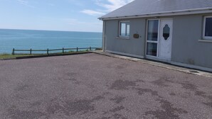 A coastal building with a grey roof, a white door, and a small window.
