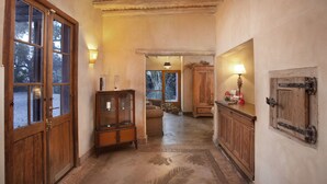 Een hal met houten deuren, een kast en een lamp.