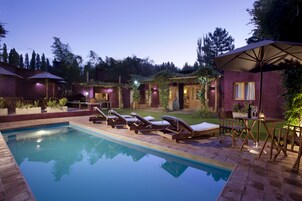 Una piscina al aire libre, sillones reclinables de piscina