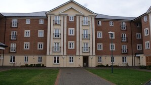 Un immeuble à plusieurs étages doté d’une façade symétrique, de grandes fenêtres et d’une entrée centrale.