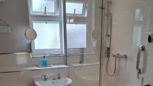 Een badkamer met toilet, wastafel en douchecabine.