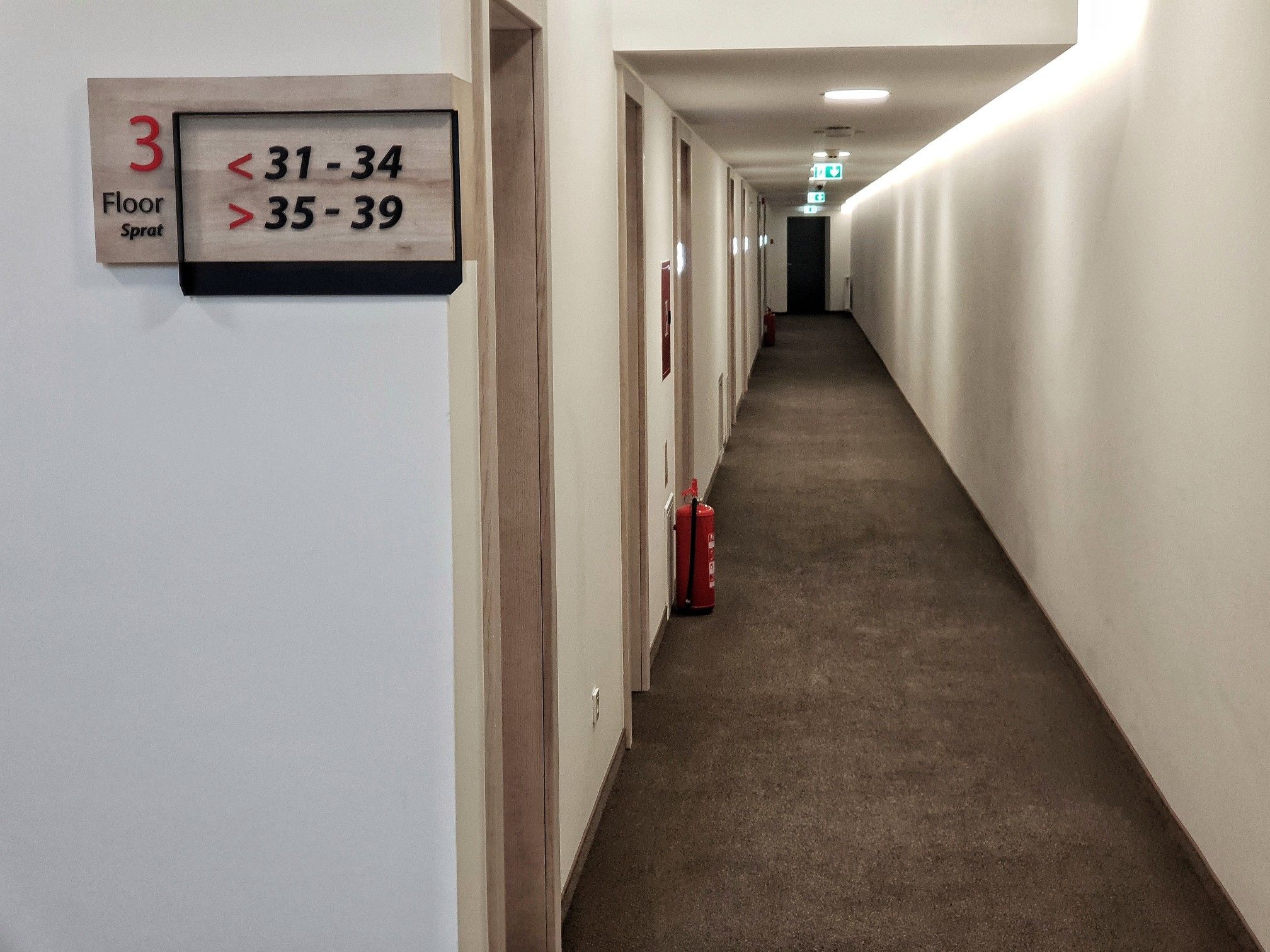Pasillo con un cartel que indica los números de habitación 31 a 34 y 35 a 39 en el tercer piso.