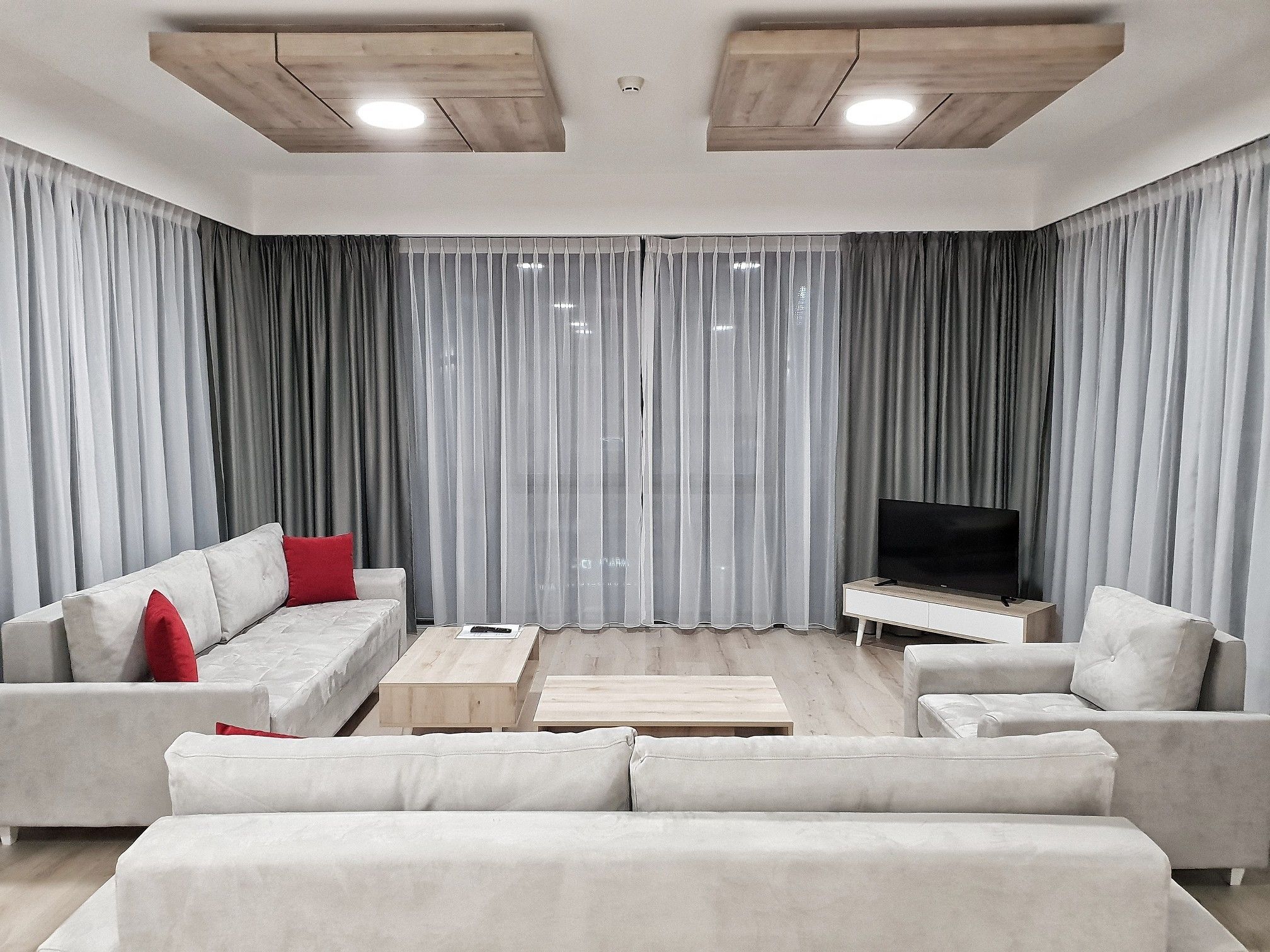Uma sala de estar moderna com um conjunto de sofá, uma mesa de centro e uma televisão.