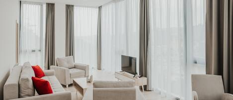 A modern living room with a sofa set, a coffee table, and a TV.