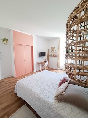Relax in this inviting bedroom with a large bed, desk, and flat-screen TV.