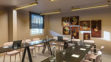 Une salle de conférence avec une longue table, des chaises, des ordinateurs portables et des œuvres d’art accrochées aux murs.