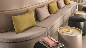 Ein modernes Interieur mit einer langen, gebogenen Couch, runden Spiegeln und einem minimalistischen Design.
