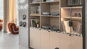 Ein modernes Zimmer mit Bücherregal, einer Neonleuchtreklame und einer gemütlichen Sitzecke.