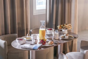 Un desayuno con cruasanes, fresas, caf é y jugo sobre una mesa.