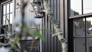 A building facade with a metal lantern, a window with a grid pattern, and a door with a handle.