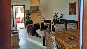 A modern living room with a sofa set, a wooden coffee table, and a staircase leading to an upper floor.