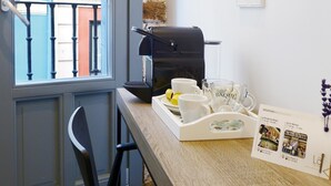 A breakfast setup with a coffee machine, a tray of white cups, and a menu on the table. - Pensión Lo Bilbao (Bilbao)