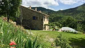 Ein Steinhaus mit Garten und Bergblick.