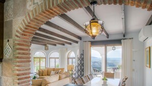 Un accogliente soggiorno con un arco in mattoni, un divano e un tavolo da pranzo.