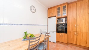 A kitchen with wooden cabinets, a microwave, and a refrigerator. - LLAC GRAN - Chalet with terrace in Port d'Alcudia. Free WiFi (Port d´Alcudia)