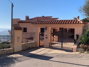 Ein Haus mit befestigtem Eingang, Steinmauern und einem Ziegeldach.