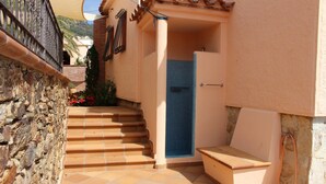 A stone staircase leading to a door with a blue-tiled shower area.