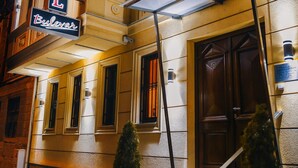 A hotel with a prominent sign, a covered entrance, and a brick facade. - Hotel Bulevar (Bitola)