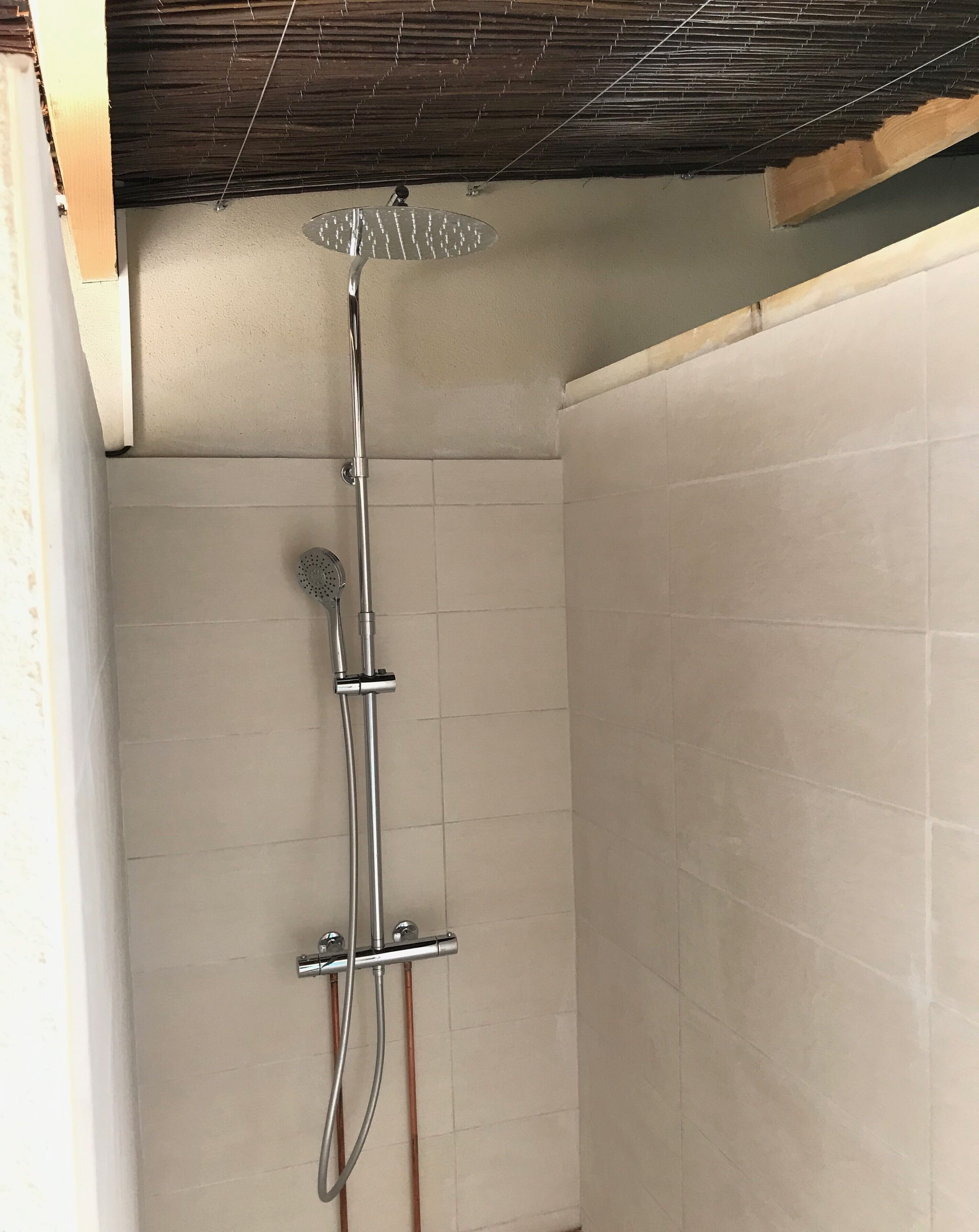 Une douche équipée d’un pommeau de douche à main, d’un pommeau de douche fixé au mur et d’un accessoire de douche à main.