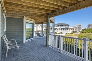 A covered porch with a view of neighboring houses.