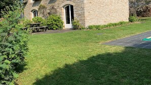 A stone house with a sloped roof, a wooden bench, and a well-maintained lawn. - Villa with private pool, sea view and beautiful beaches within walking distance. (Sarzeau)