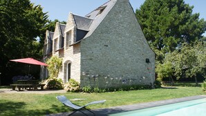 A stone building with a swimming pool, a lawn, and a red umbrella. - Villa with private pool, sea view and beautiful beaches within walking distance. (Sarzeau)