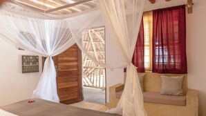 Quarto com cama, sofá e porta de madeira.