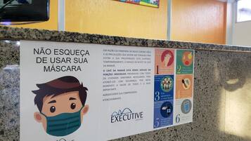 A sign in a hotel lobby advising not to leave masks unattended, with health and safety guidelines.