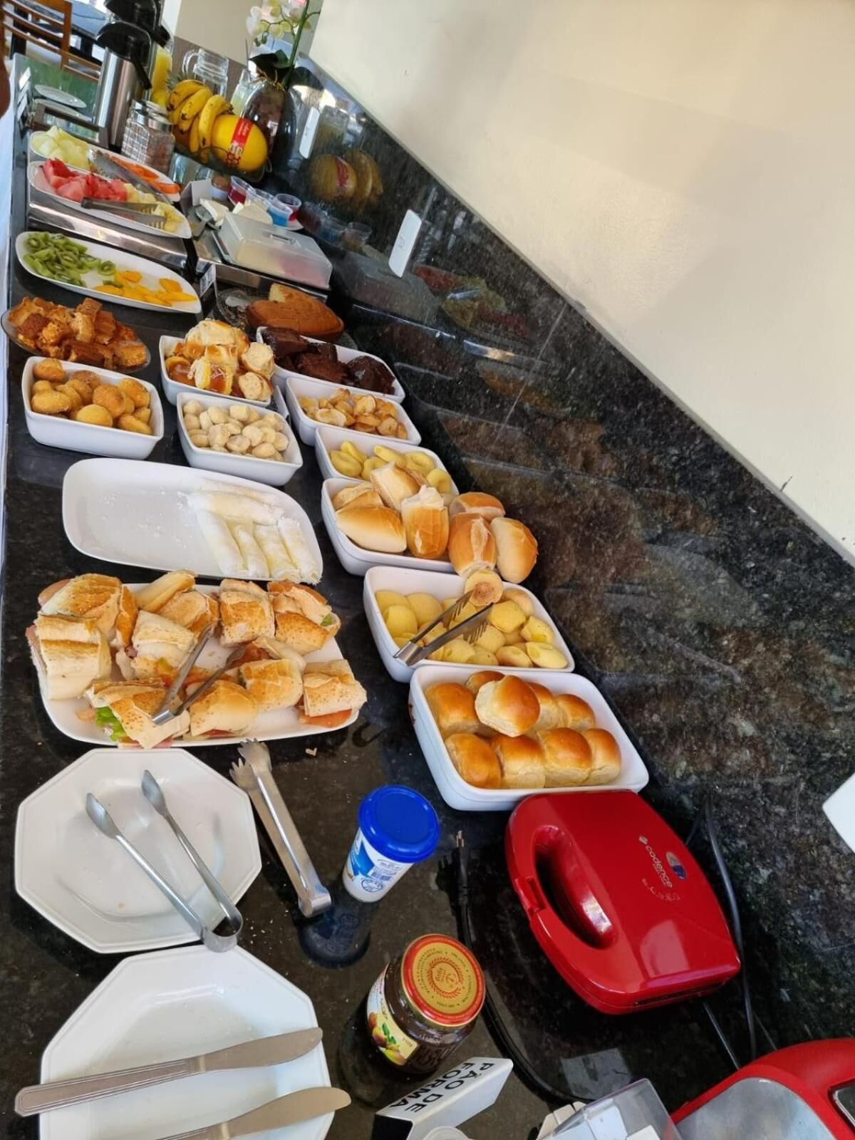 Um buffet com diversos alimentos e utensílios.