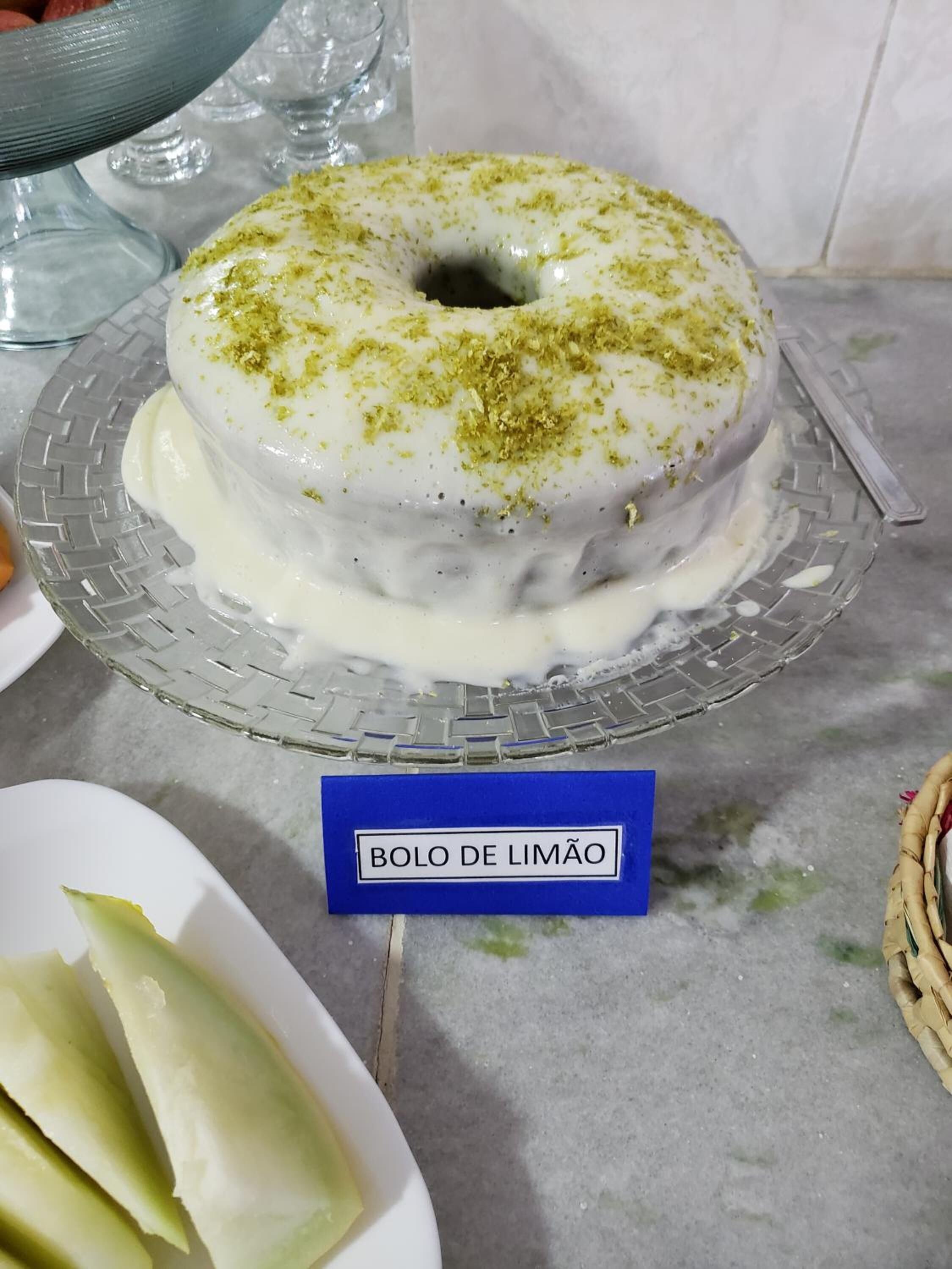 A dessert called bolo de limão on a glass plate with a label.