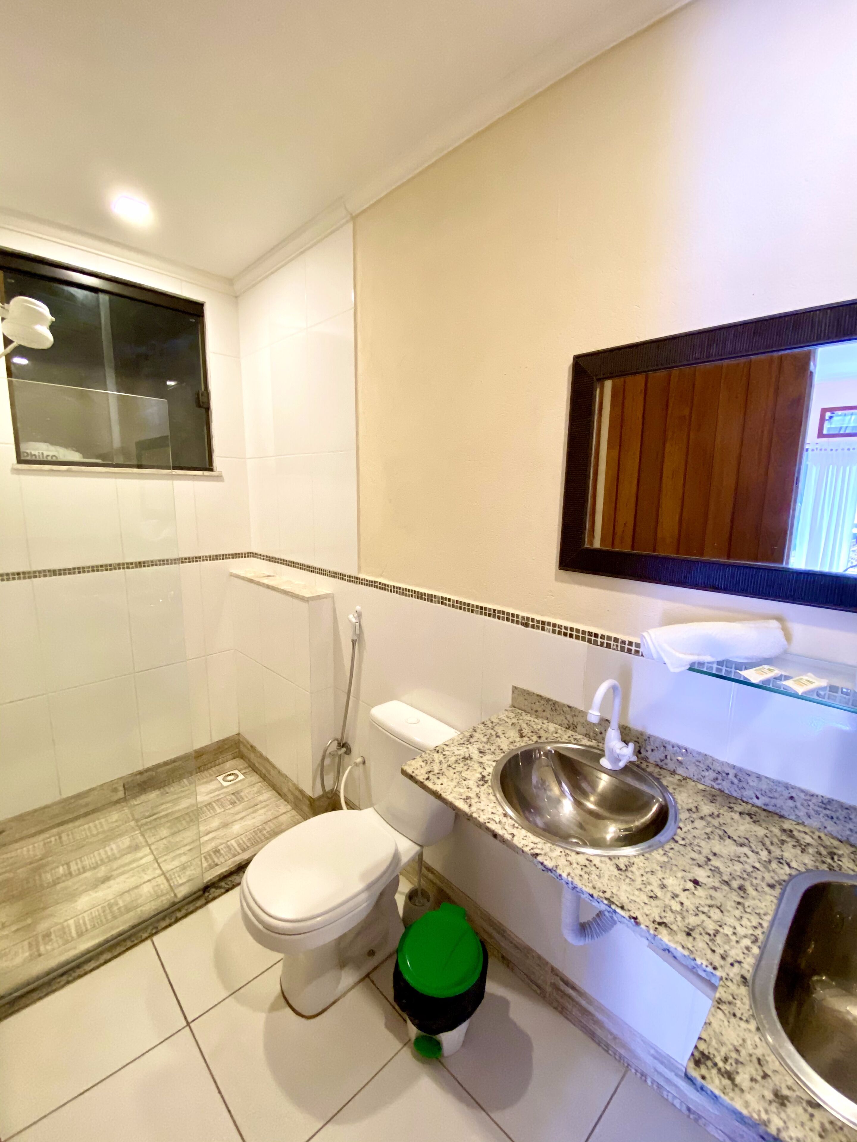 A bathroom with a toilet, sink, and shower.