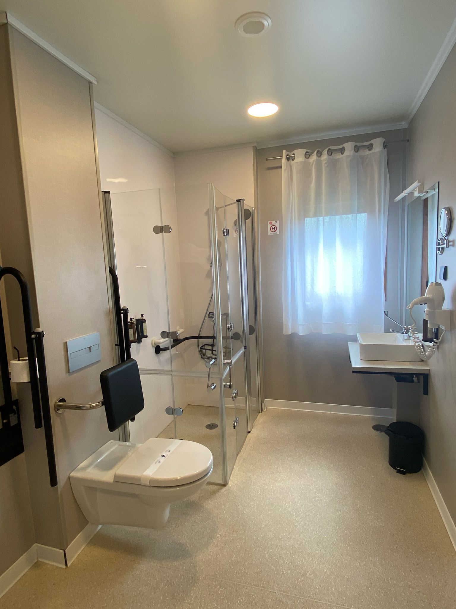 Un baño moderno con inodoro, ducha y lavamanos.