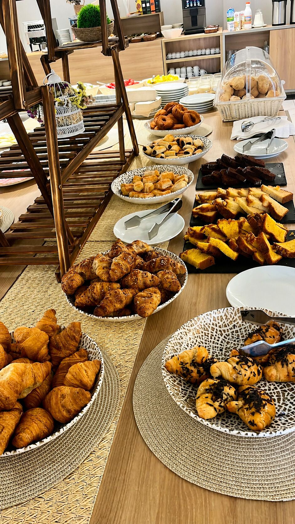 A buffet table with various food items including pastries, bread, and other baked goods.