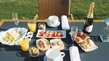 Mesa lista para el desayuno con diversas comidas y bebidas.