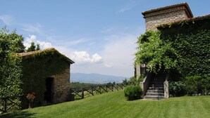 A stone building with ivy-covered walls and a staircase leading up to a door. - Panoramic holiday apartment Torre Colombaia 4+2 pax (Spoleto)