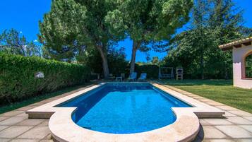 Una piscina al aire libre, tumbonas
