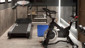 Un gimnasio moderno con cinta de correr, bicicleta estática y equipo de ejercicios.